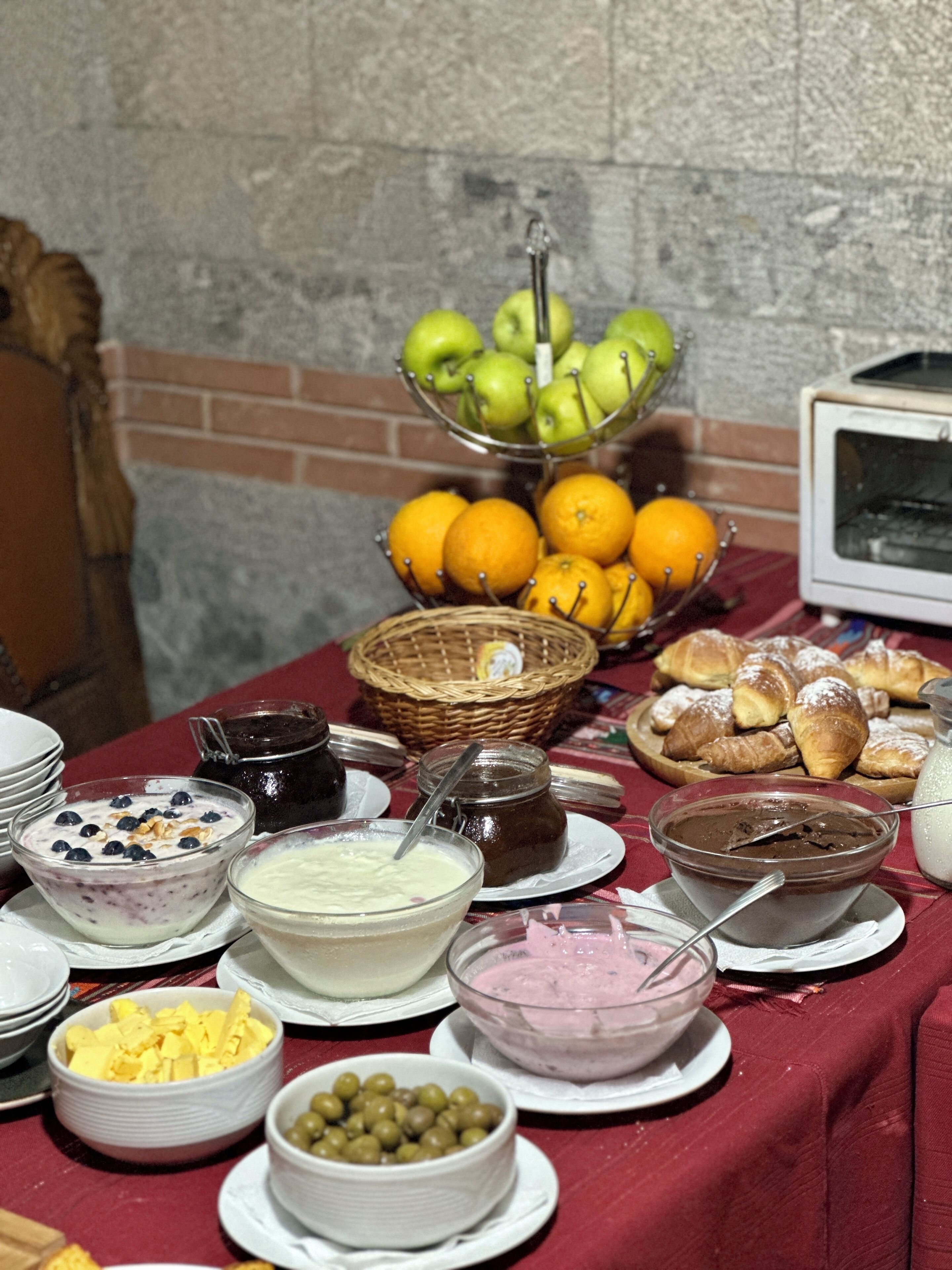 Un buffet de petit-déjeuner proposant une variété d'aliments, notamment des fruits, des viennoiseries et des produits laitiers.
