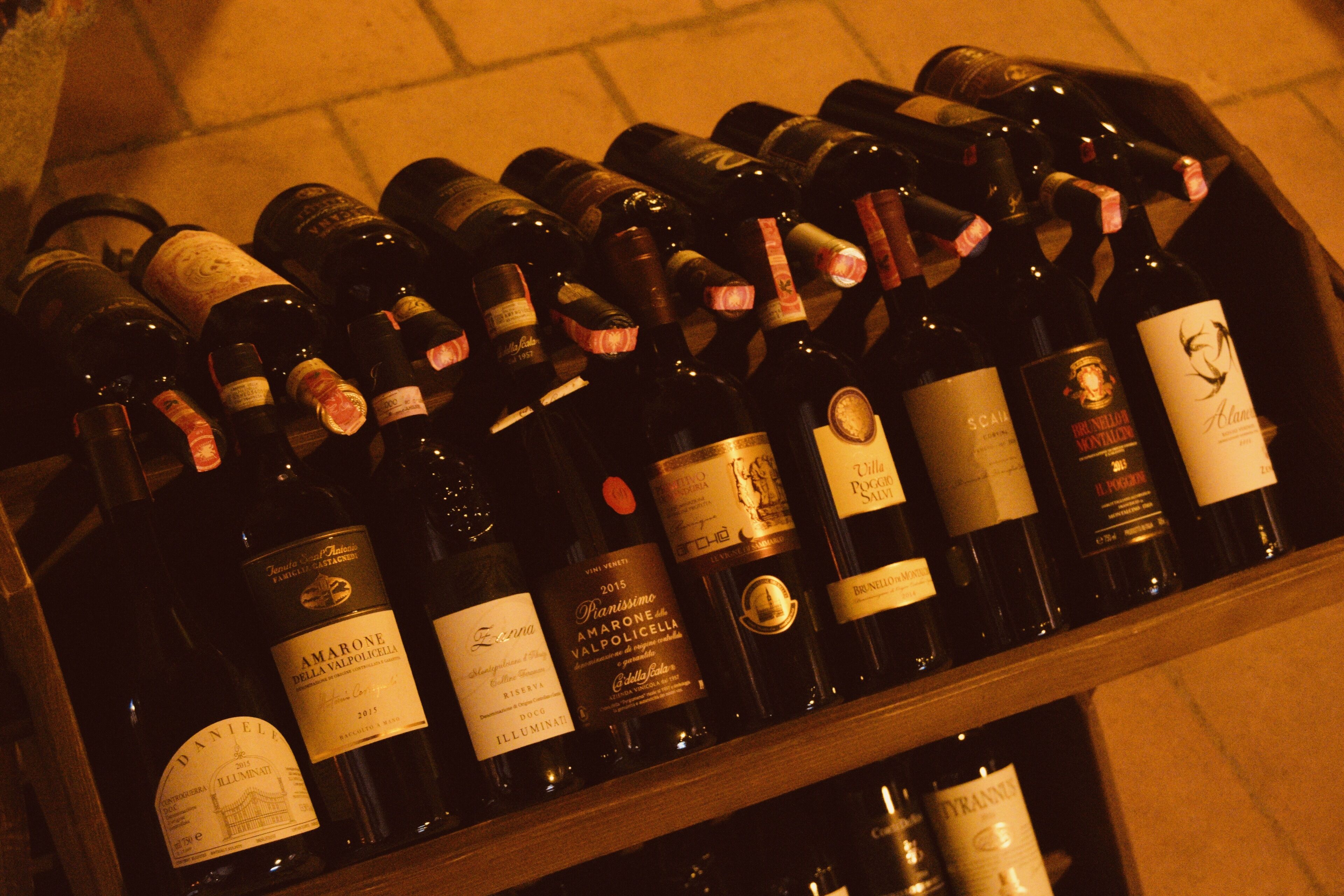 A wooden wine rack filled with various bottles of wine, each with distinct labels.