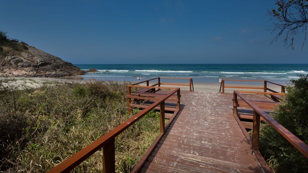A wooden boardwalk leading to a beach with ocean views. - Burleigh Point Holiday Apartments (Miami)