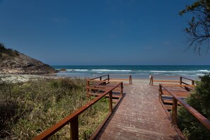 A wooden boardwalk leading to a beach with ocean views. - Burleigh Point Holiday Apartments (Miami)