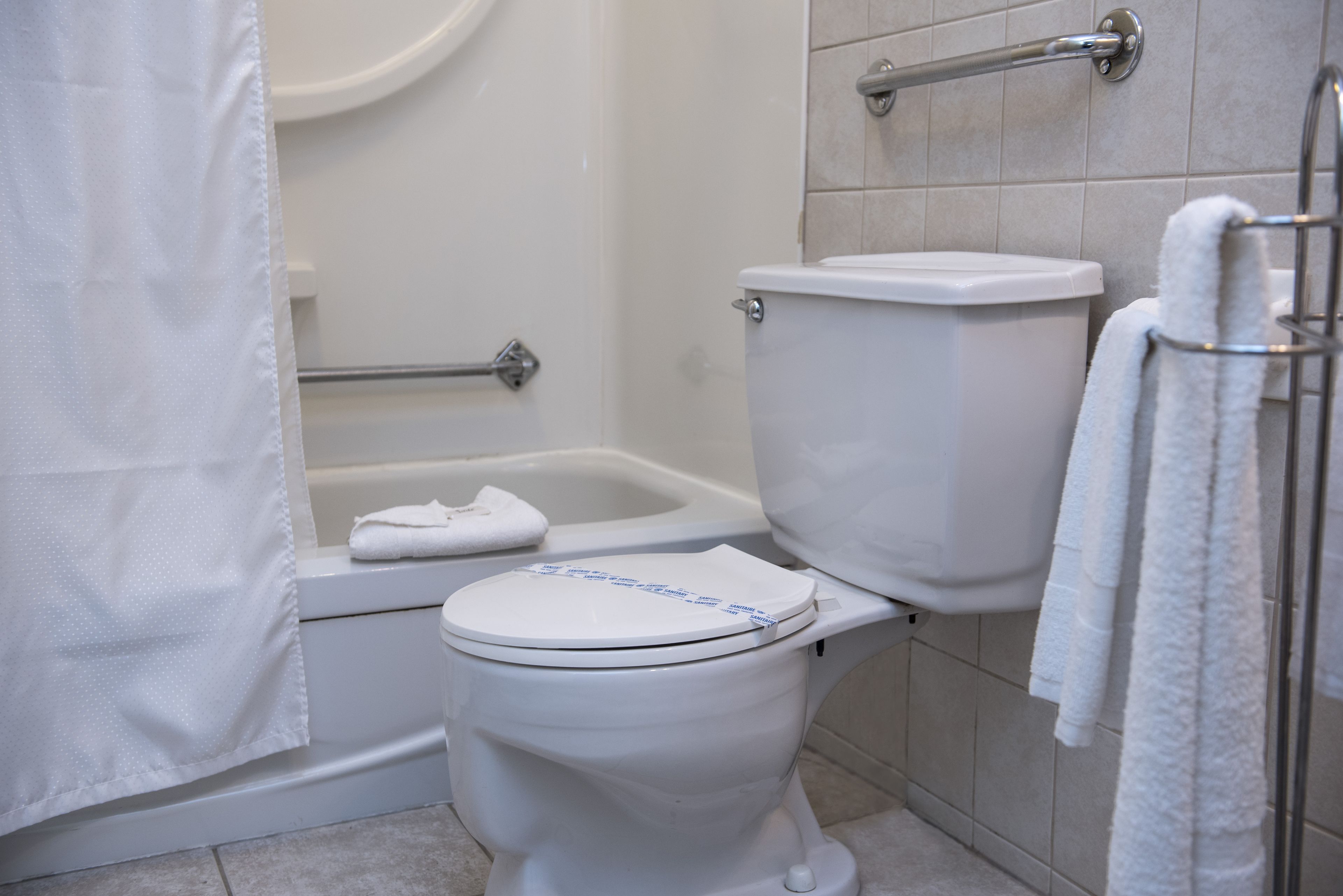 Une salle de bain équipée de toilettes, d’une baignoire et d’un porte-serviettes.