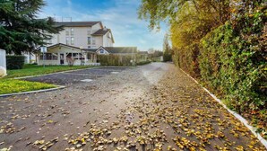 Eine Wohnstraße mit Häusern, einer Auffahrt und einer Hecke.