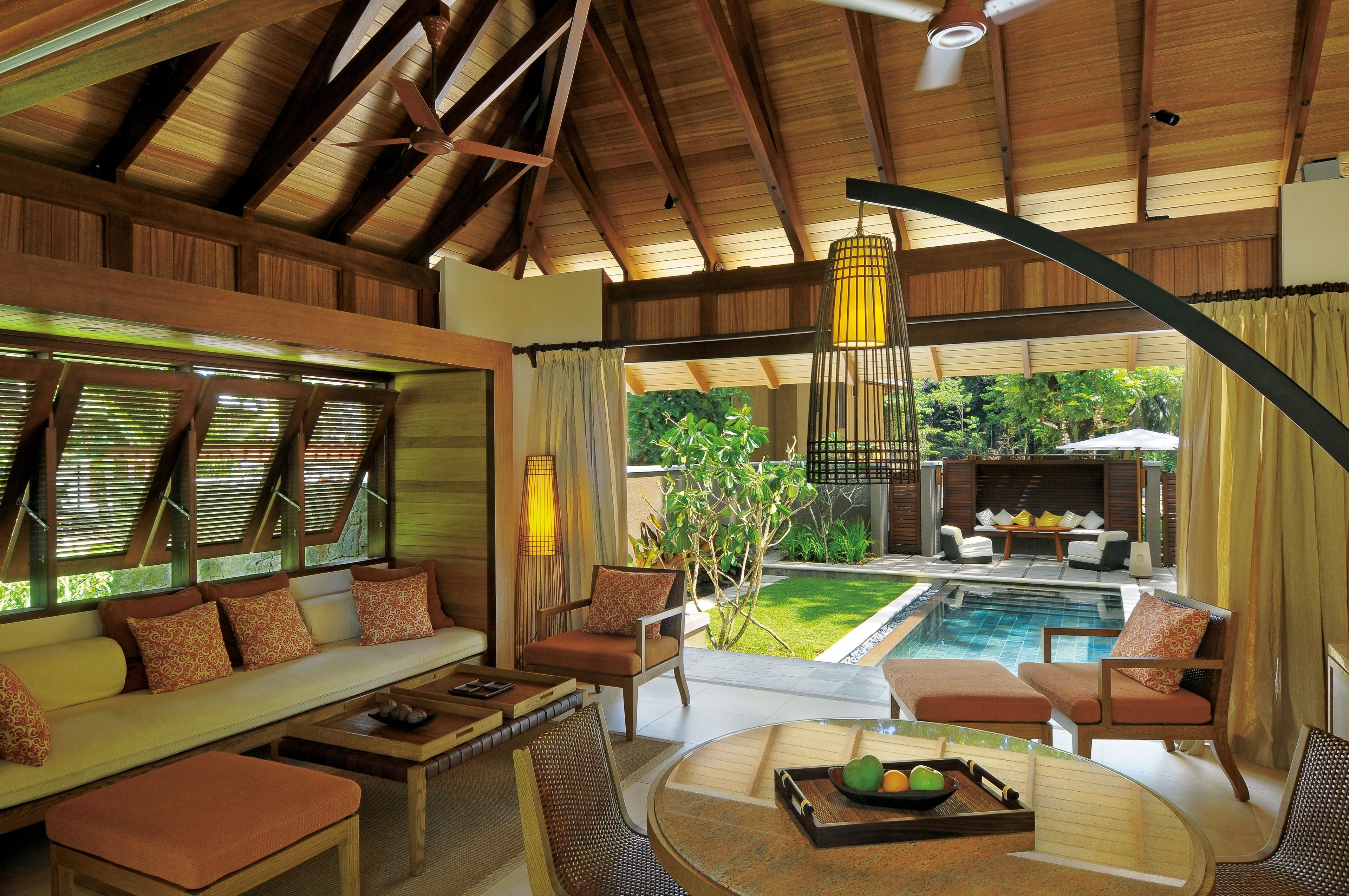 A spacious indoor area with a pool, seating arrangements, and a view of the outdoors.