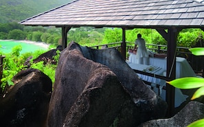 A gazebo with a view of a beach and lush greenery.