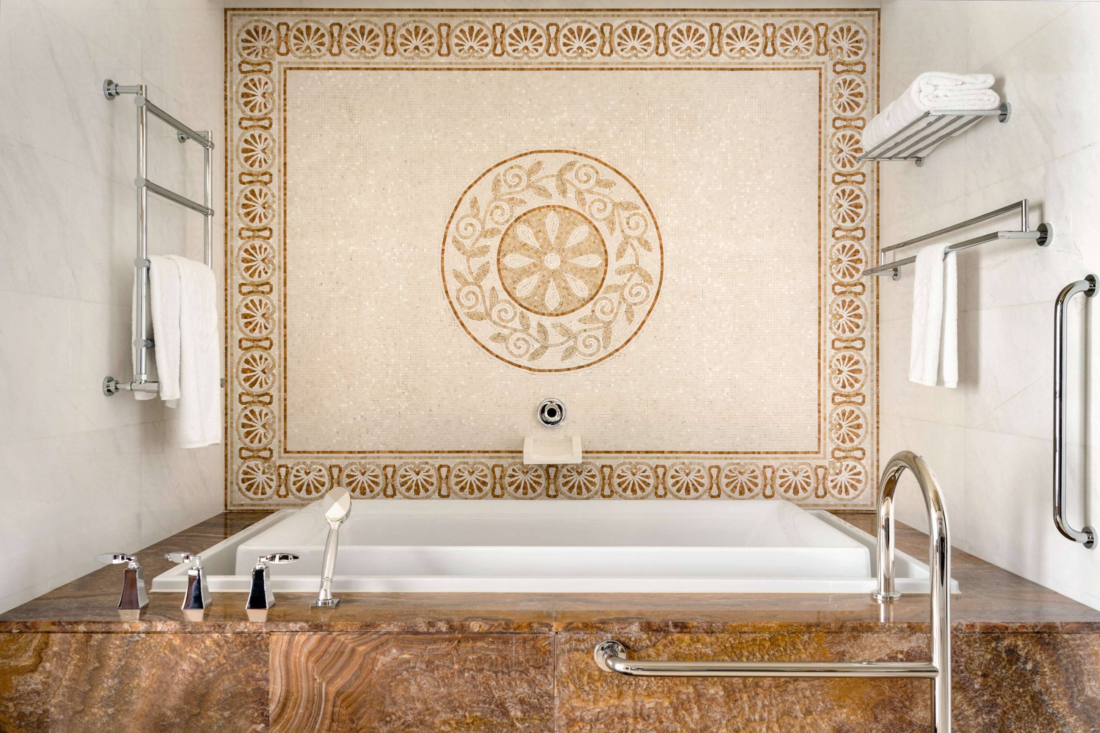 A bathroom with a bathtub, a sink with three faucets, and a towel rack.
