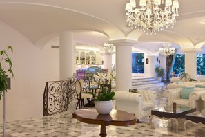 A luxurious lobby with white furniture, chandeliers, and a marble floor. - Grand Hotel La Favorita (Sorrento)