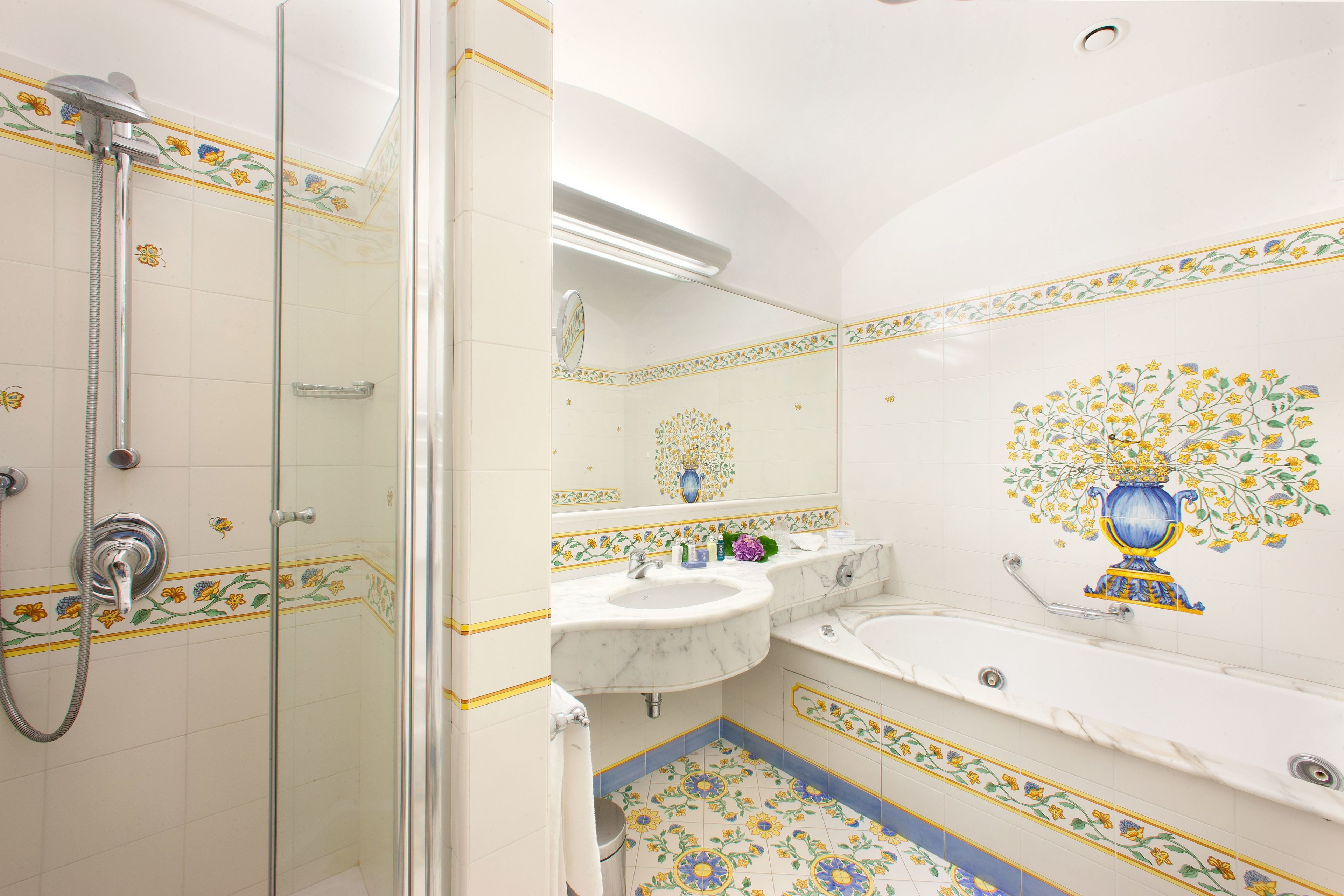 A bathroom with a glass-enclosed shower, a sink, and a bathtub.