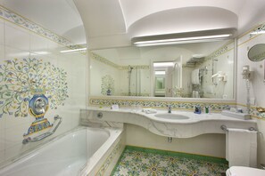 A bathroom with a bathtub, a sink, and a toilet. - Grand Hotel La Favorita (Sorrento)