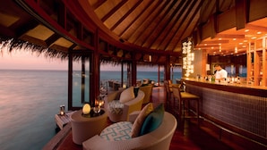 A bar area with seating and a view of the ocean. - Constance Halaveli (Halaveli)