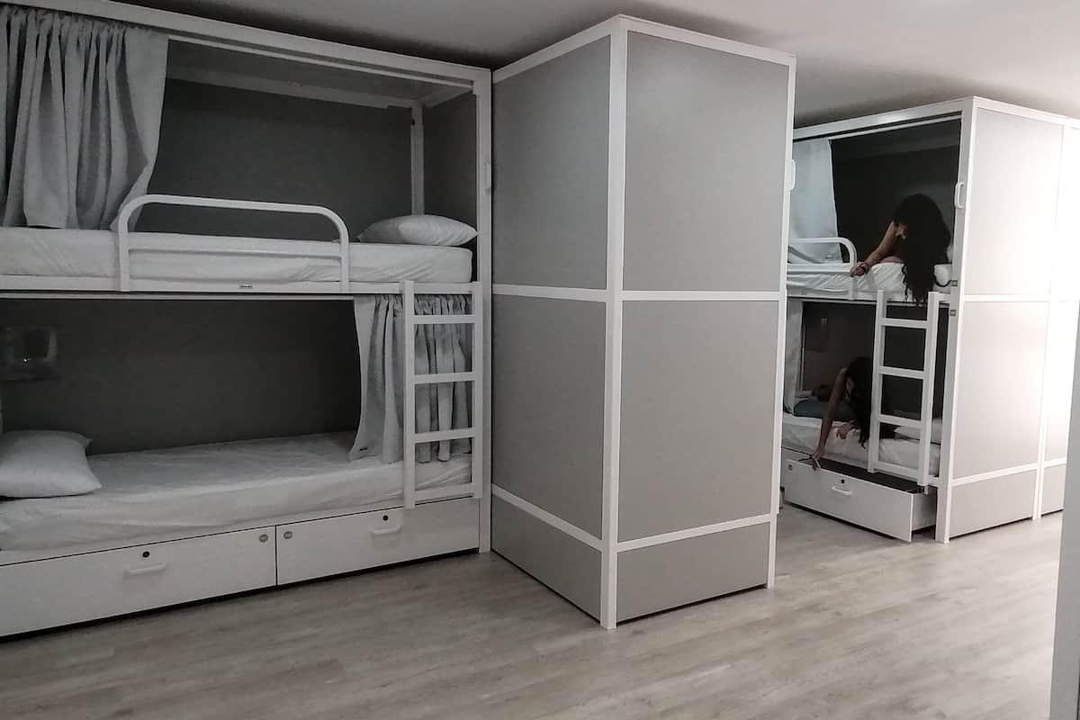 Een kamer met stapelbedden, een garderobe en een trap.