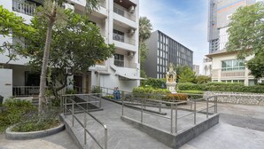 A modern building with a courtyard, a statue, and a staircase.