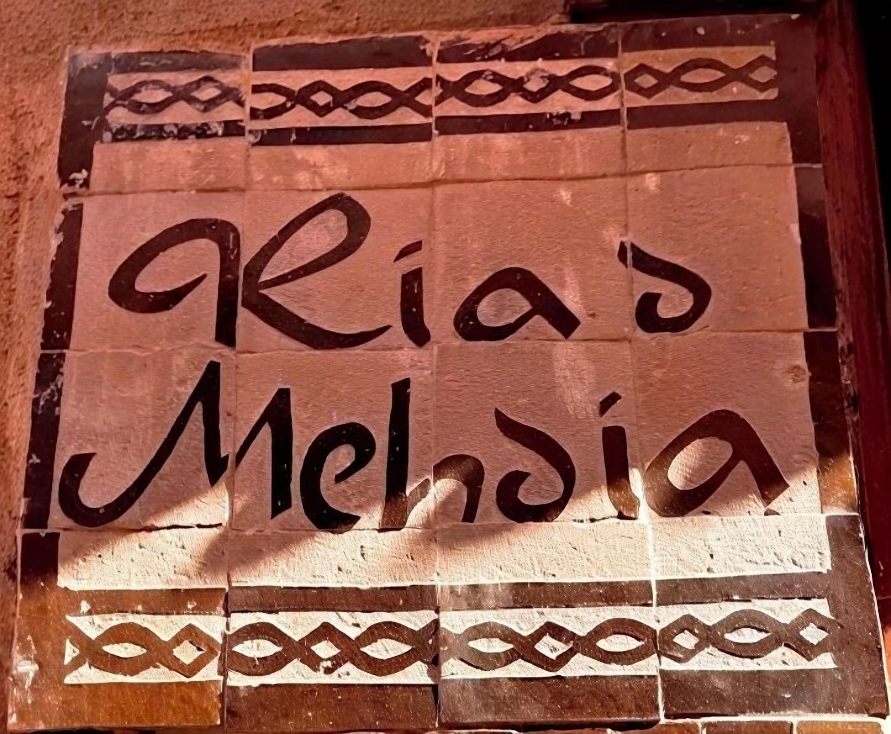 Pared de azulejos con el texto "Riad Mejdia" en una tipografía decorativa.