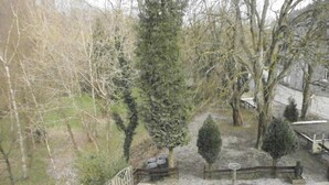 A garden with various trees and a wooden fence. - Hotel Cobut (Onhaye)