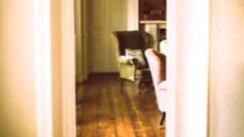 A hallway with a wooden floor and a white door at the end.