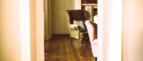 A hallway with a wooden floor and a white door at the end.
