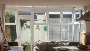 Una cocina con comedor, un sofá y vistas a través de puertas de vidrio.