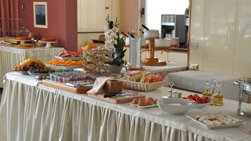 A buffet table with various food items and a coffee station.