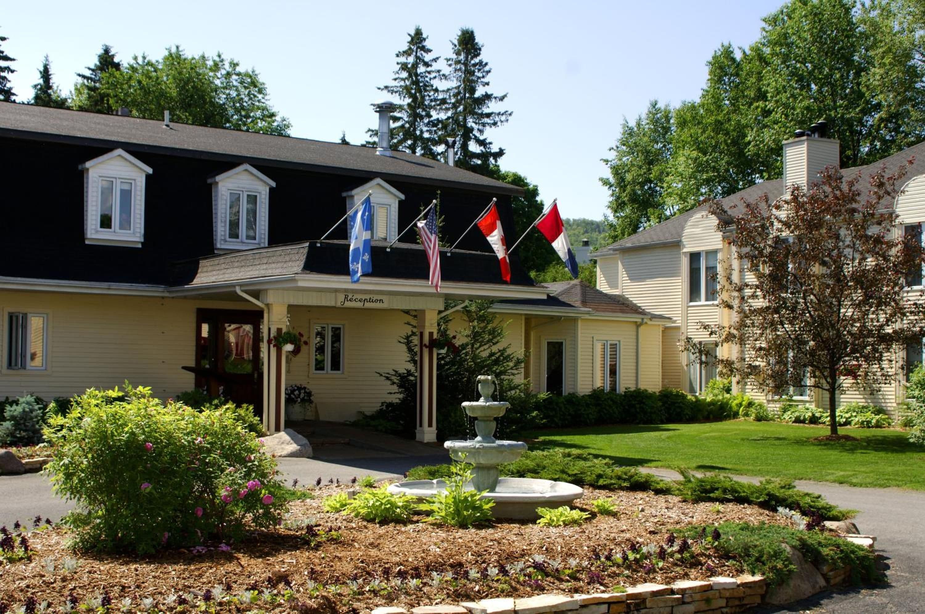A two-story building with a reception area, a fountain, and a garden with various plants.