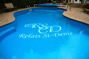 A swimming pool with a logo reading "R&D Relais St-Denis" on the water's surface. - Relais St-Denis (Saint-Sauveur)