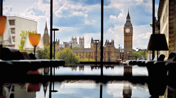 A view of the Houses of Parliament and Big Ben from a room with a reflective surface.