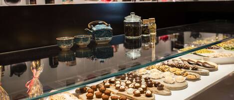 A display of pastries and tea sets in a store.