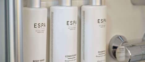 Drie flessen ESPA douchegel, conditioner en shampoo in een badkamer.