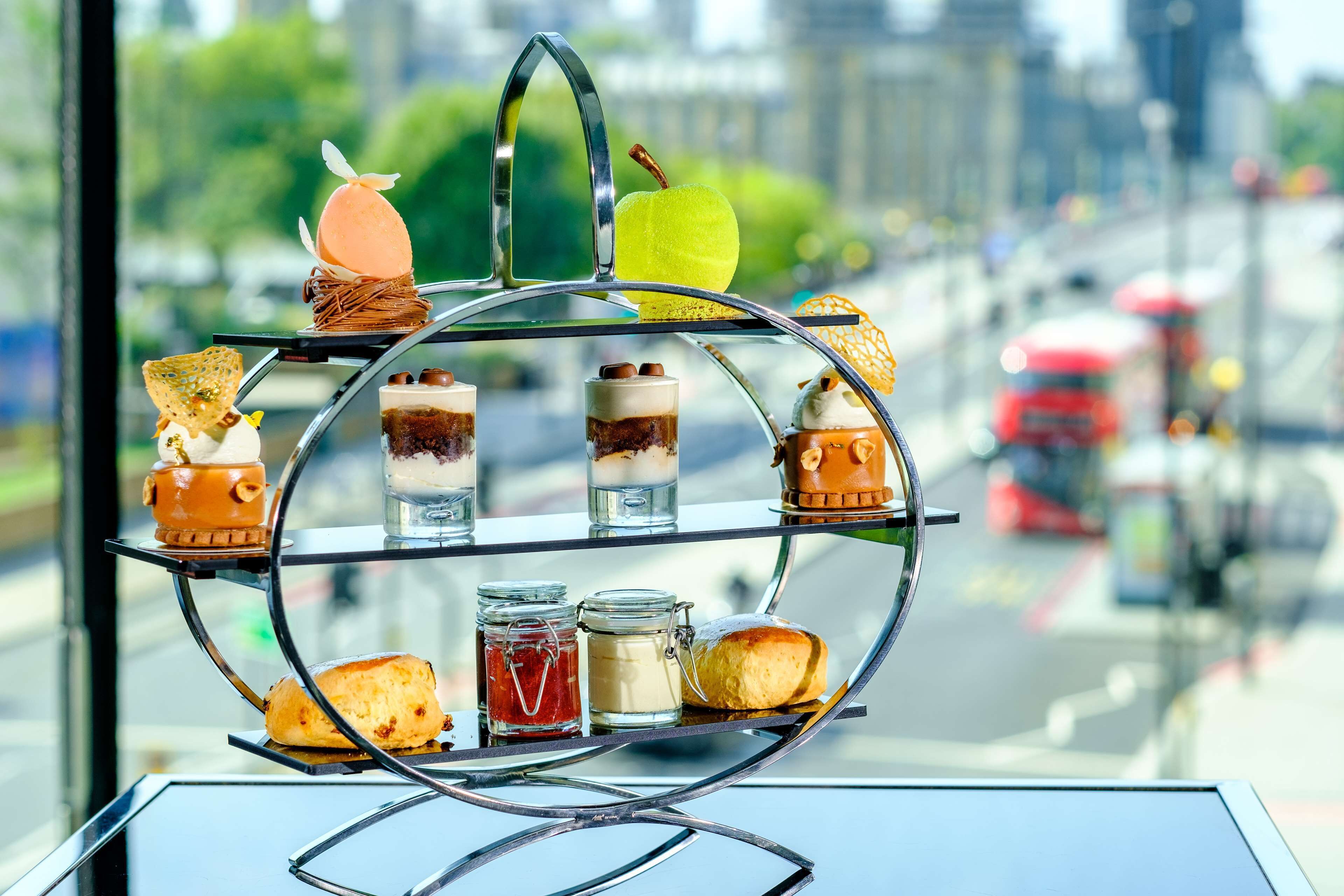 Una presentación de postres en varios niveles, con diferentes pasteles y dulces.