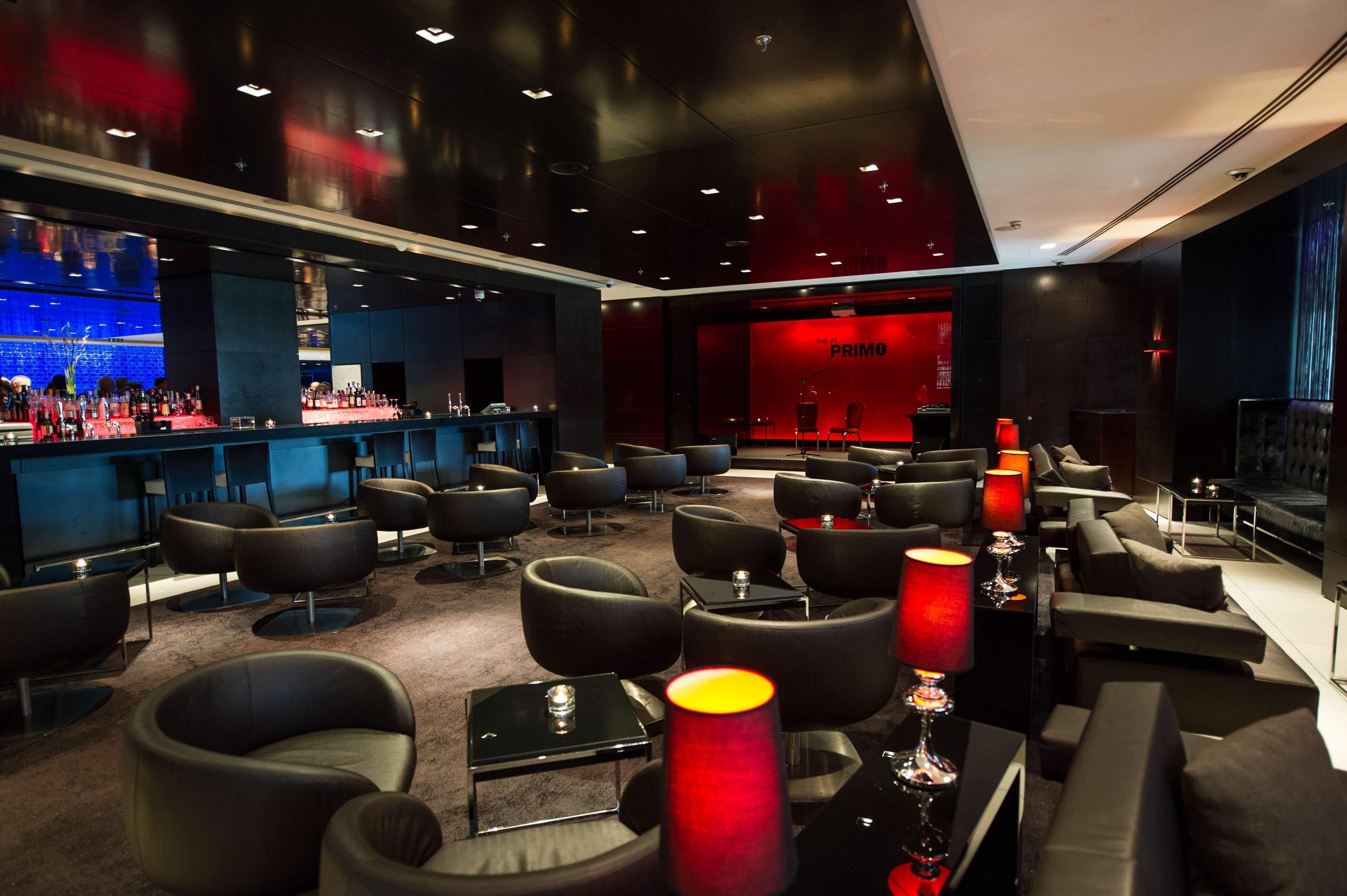 A modern lounge area with sofas, tables, and a bar.
