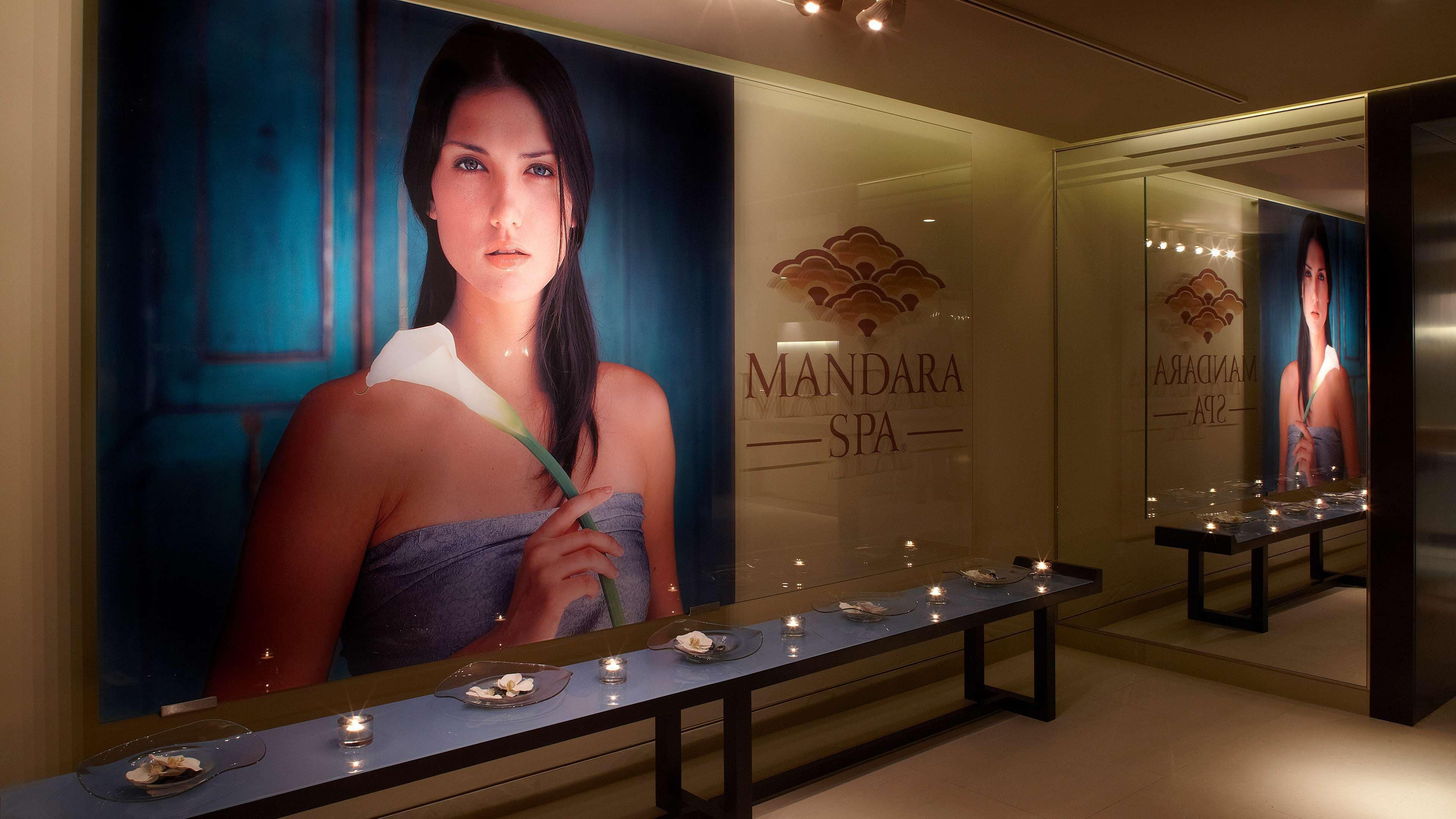 A spa interior with a reception desk, a large poster of a woman, and a sign reading 'MANDARA SPA'.