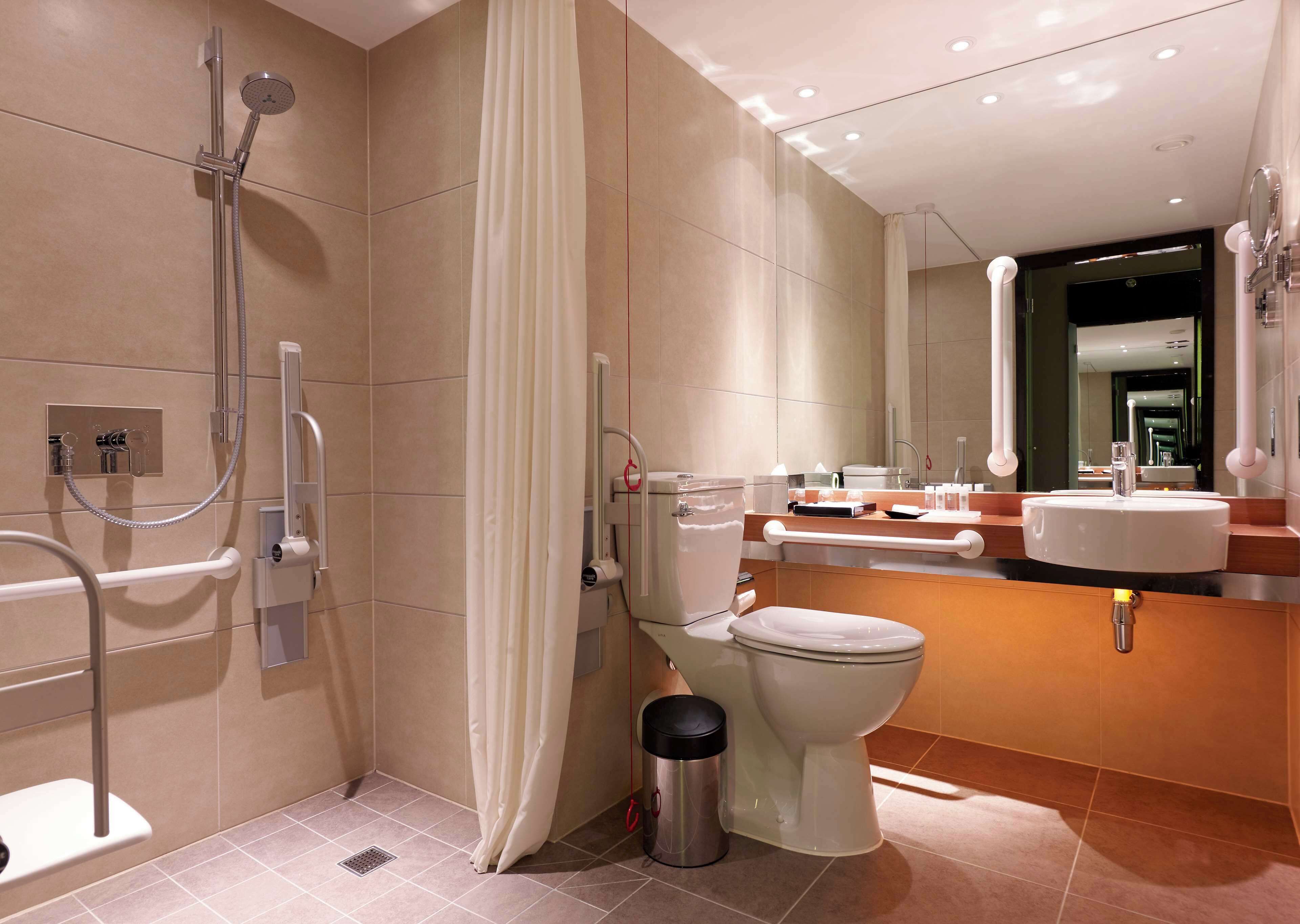 A modern bathroom with a shower, toilet, and sink.