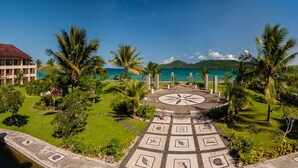 A tropical resort with a central circular pathway, palm trees, and a view of the ocean. - The Natsepa Resort & Conference Center (Salahutu)