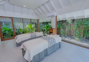 Una habitación con dos camas, ventanas amplias y vistas a zonas verdes.
