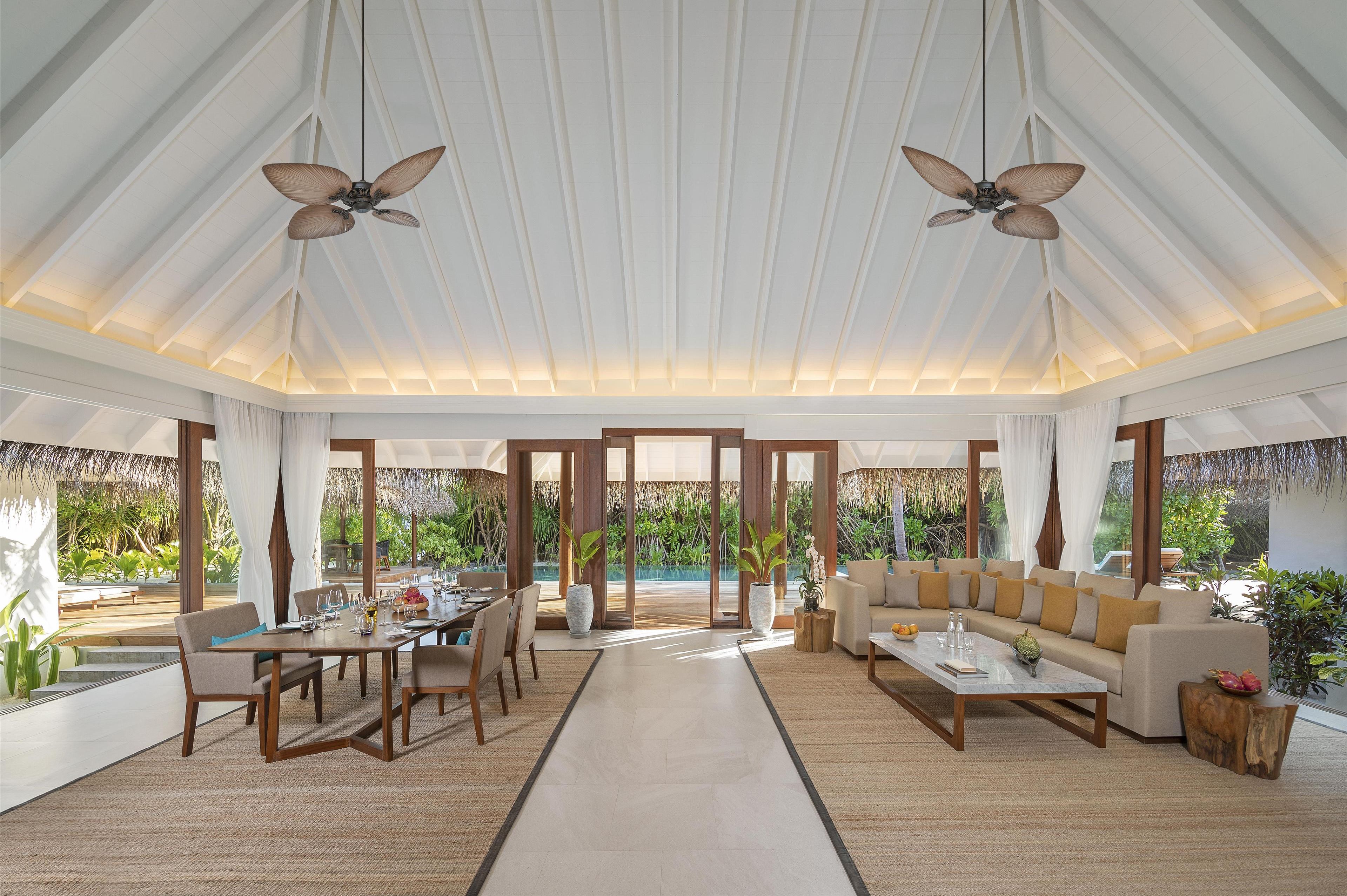 Un salón amplio con techo alto, ventanas grandes y vistas al exterior.
