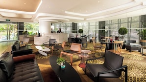 A modern lobby with leather sofas, round tables, and a reception desk. - D'Hotel Singapore managed by The Ascott Limited (Singapore)