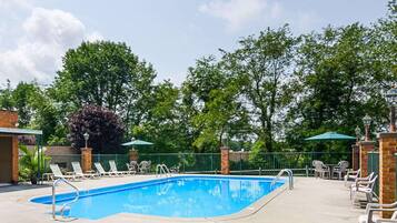 Relax by the pool surrounded by lush greenery and comfortable lounge chairs.