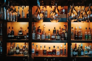 A bar with multiple shelves stocked with various bottles of alcohol. - Hotel Golf Chateau de Chailly (Chailly-sur-Armancon)