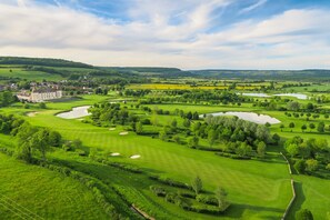 A golf course with bunkers, water hazards, and a large building in the background. - Hotel Golf Chateau de Chailly (Chailly-sur-Armancon)