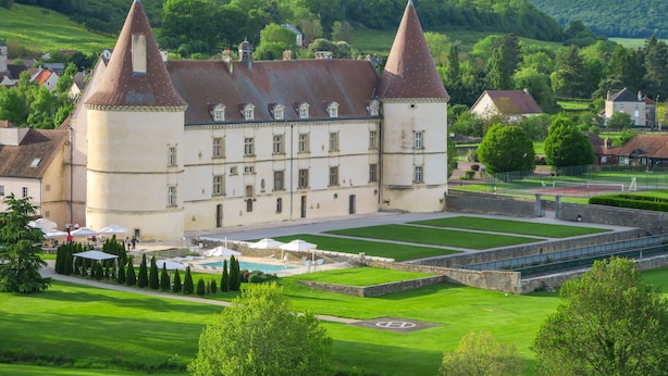 A historic building with two prominent towers, a courtyard with a swimming pool, and surrounding lush greenery. - Hotel Golf Chateau de Chailly (Chailly-sur-Armancon)