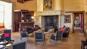 A lobby with a fireplace, seating area, and a bar. - Hotel Golf Chateau de Chailly (Chailly-sur-Armancon)
