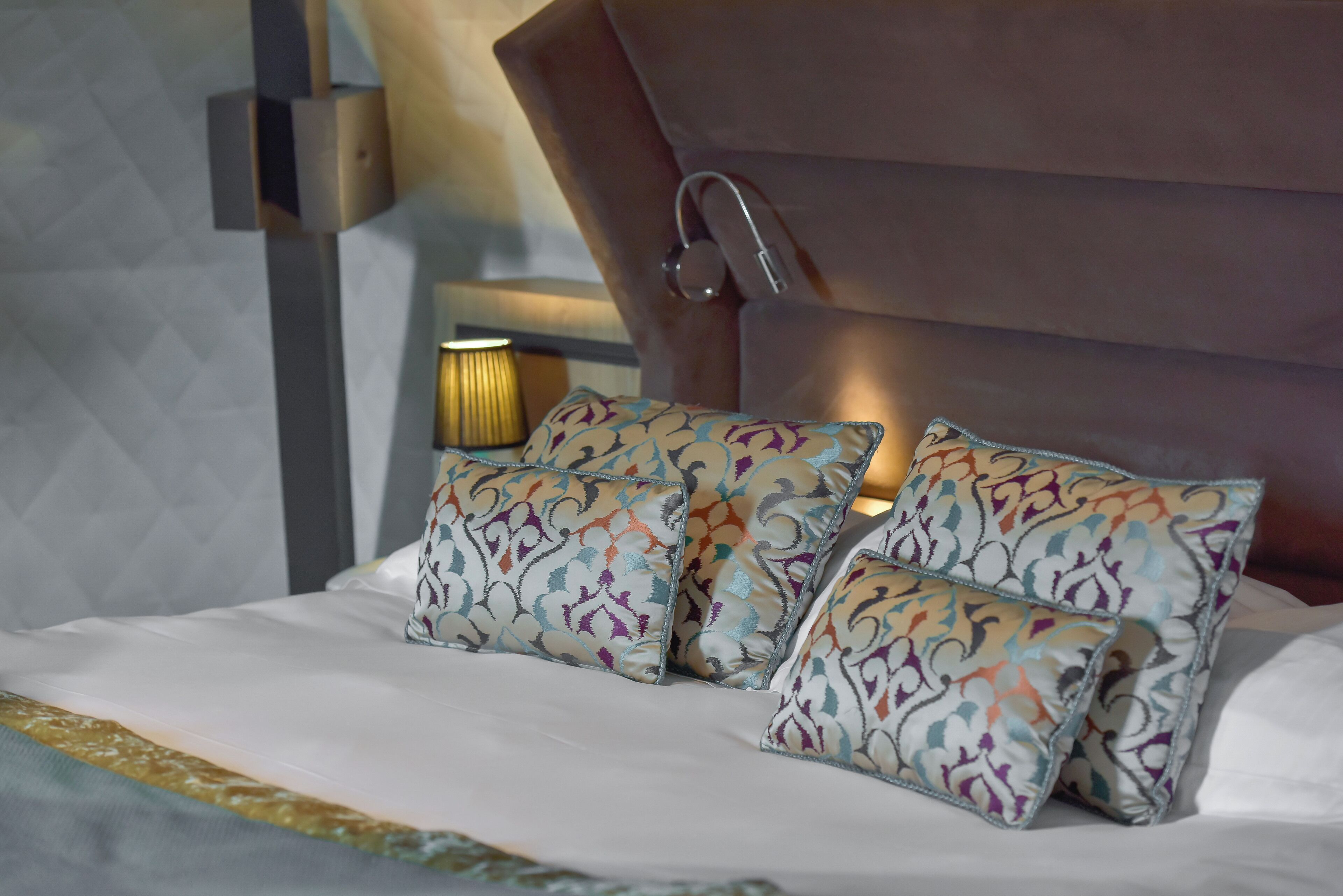 A bed with patterned pillows and a headboard.