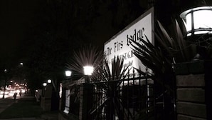 A nighttime view of a building with a sign that reads "The First Hotel." - The Firs Lodge (Hounslow)
