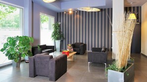 A modern lobby with seating, a reception desk, and a large window. - Residhome Clermont Ferrand Gergovia (Clermont-Ferrand)
