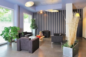 A modern lobby with seating, a reception desk, and a large window. - Residhome Clermont Ferrand Gergovia (Clermont-Ferrand)
