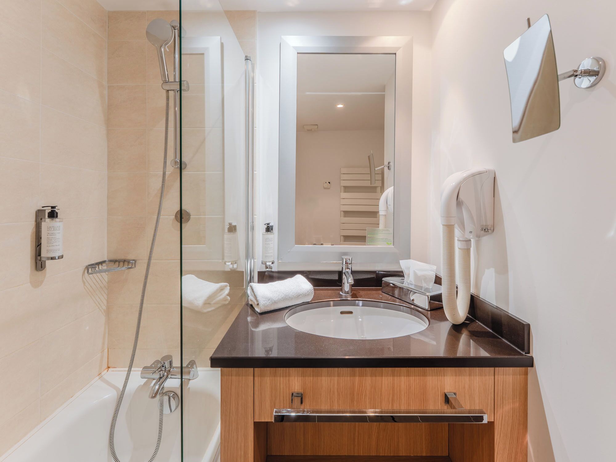 Une salle de bain moderne avec une douche à parois de verre, un lavabo avec un meuble-vasque et un miroir.