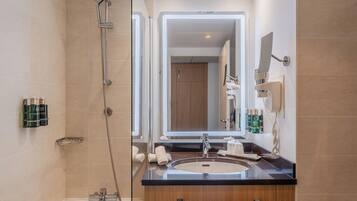 A modern bathroom with a glass-enclosed shower, a vanity with a sink, and a large mirror.