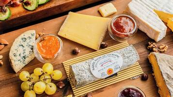 Une variété de fromages, de noix et de fruits présentés sur des planches en bois.