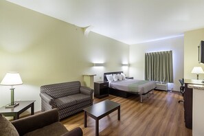 A hotel room with a bed, a sofa, a small table, and a desk. There are two lamps on the nightstands and a window with curtains. - Motel 6 Fort Worth, TX (Fort Worth)