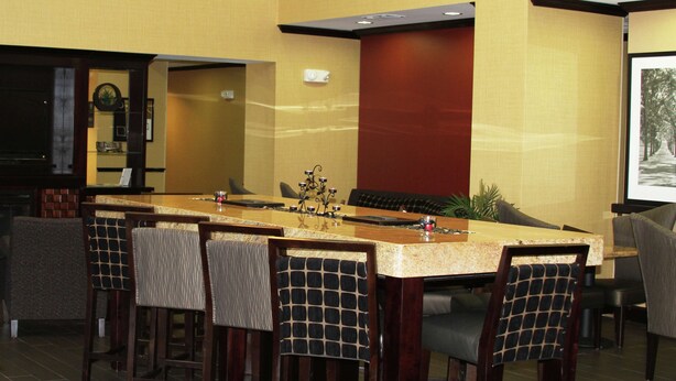 A conference room with a long table, chairs, and a television screen.