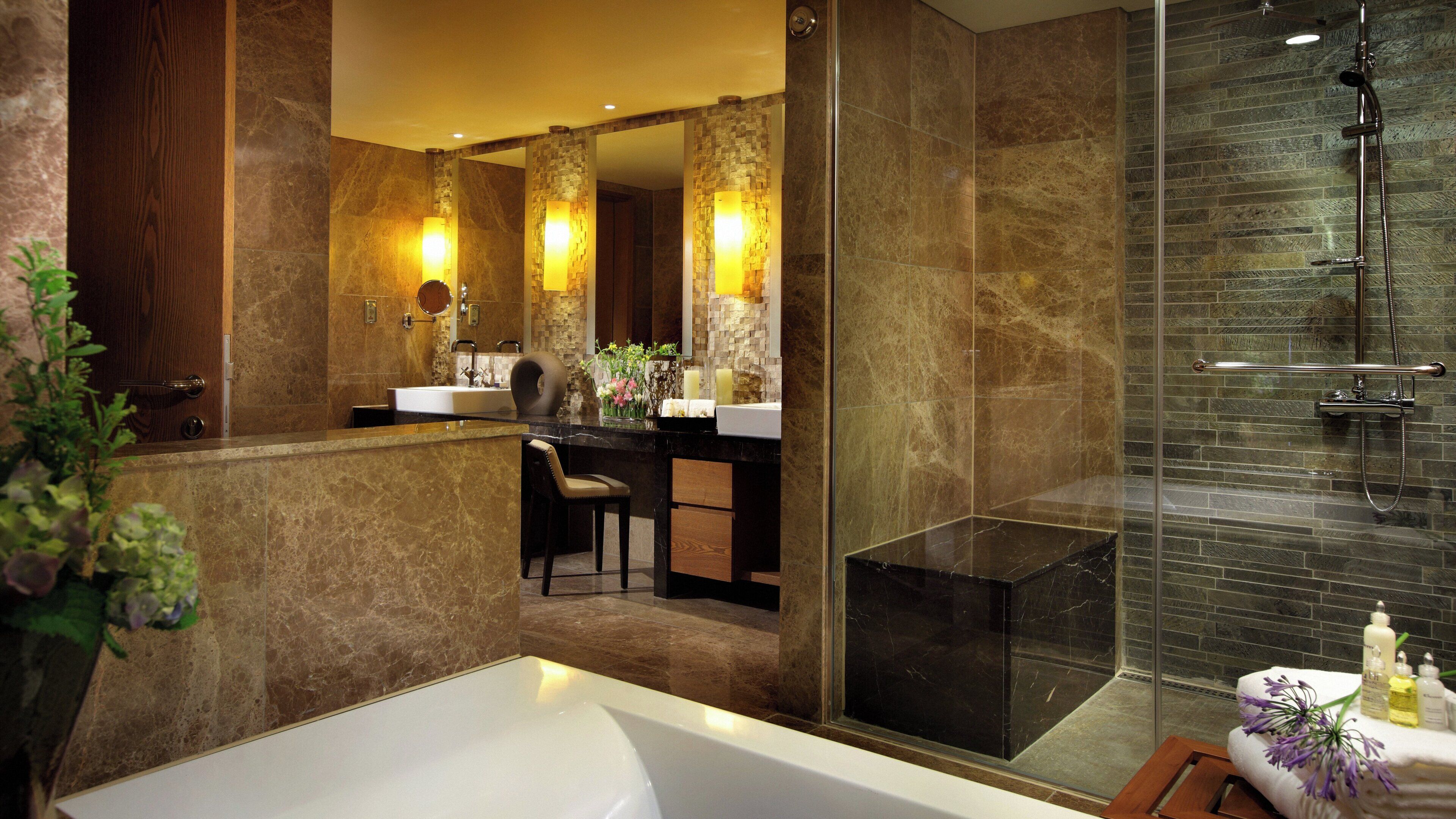 Une salle de bain moderne avec une baignoire, une douche à parois de verre, un meuble-lavabo et un miroir.