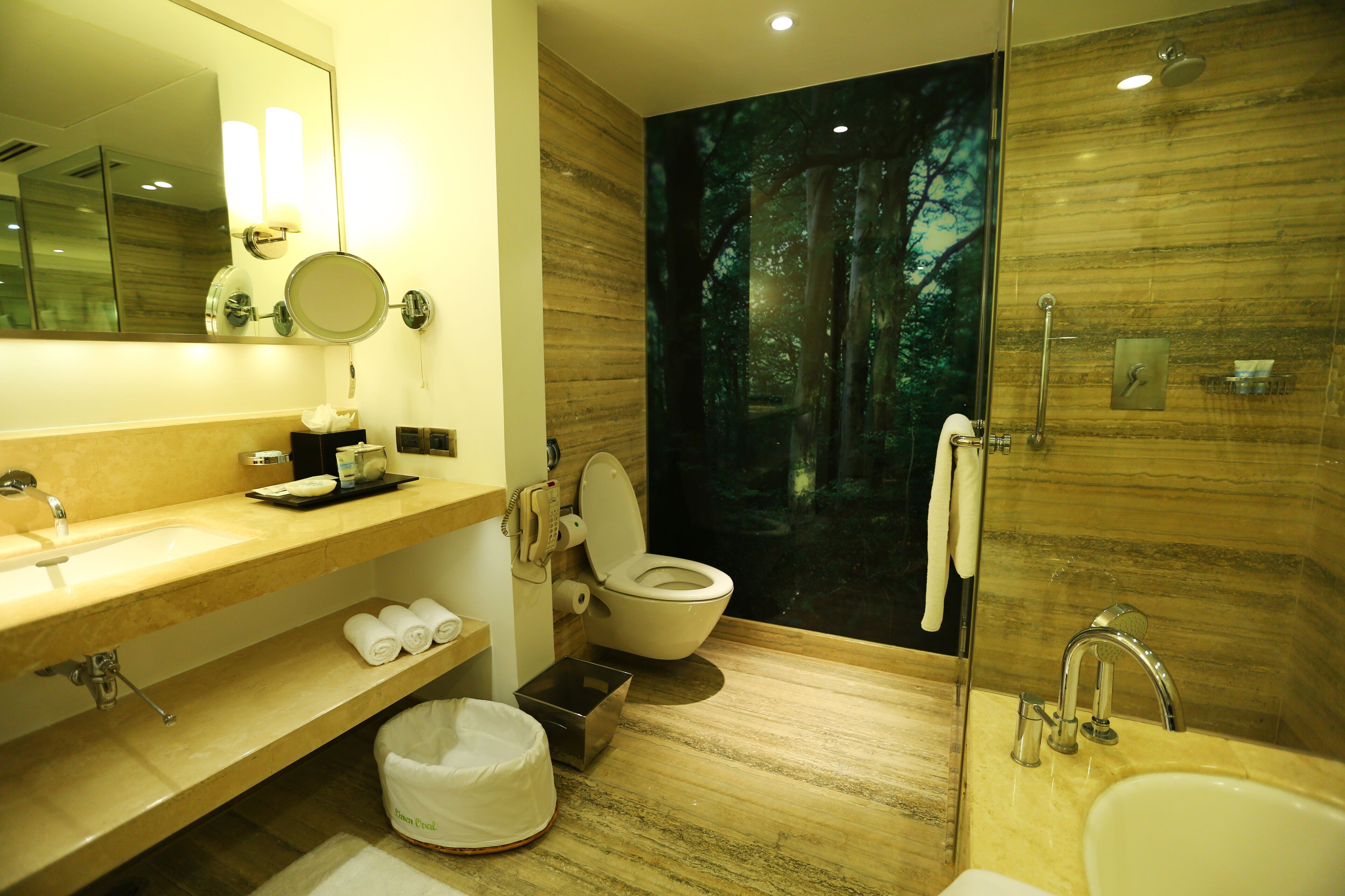 A modern bathroom with a large mirror, a sink, a toilet, and a shower area.